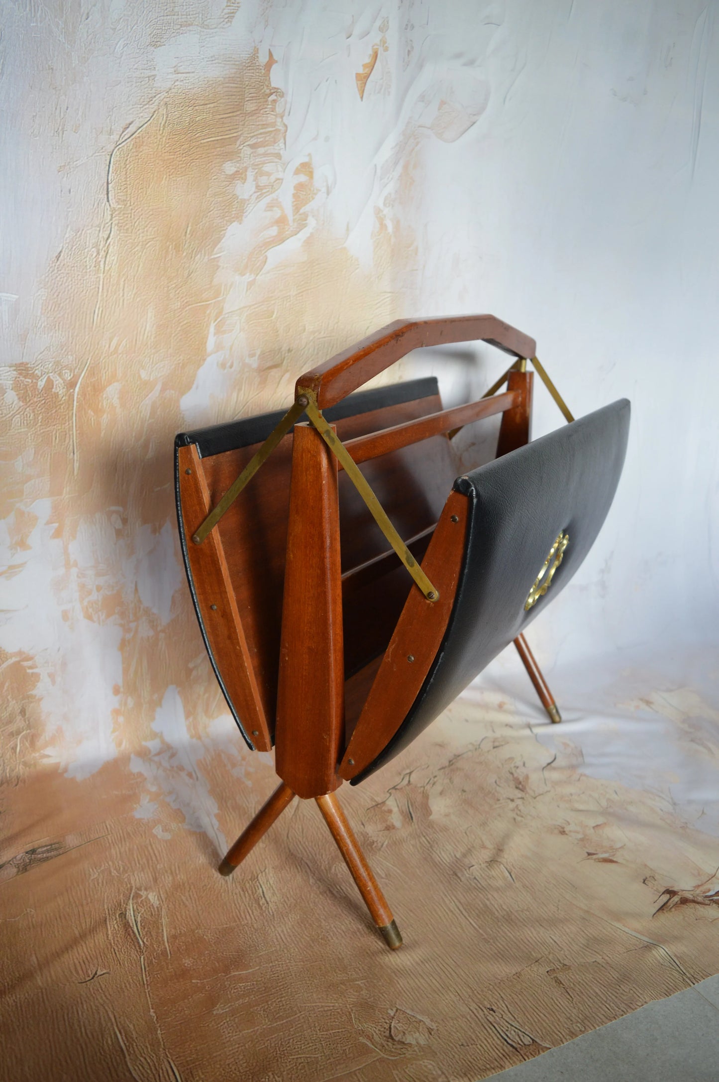Mid-century modern wooden and black leather magazine rack with tripod legs