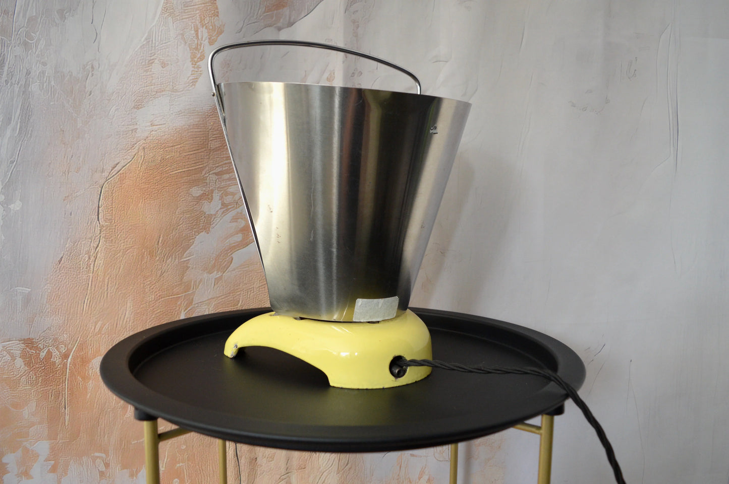 Vintage industrial metal lamp with yellow base on black round table