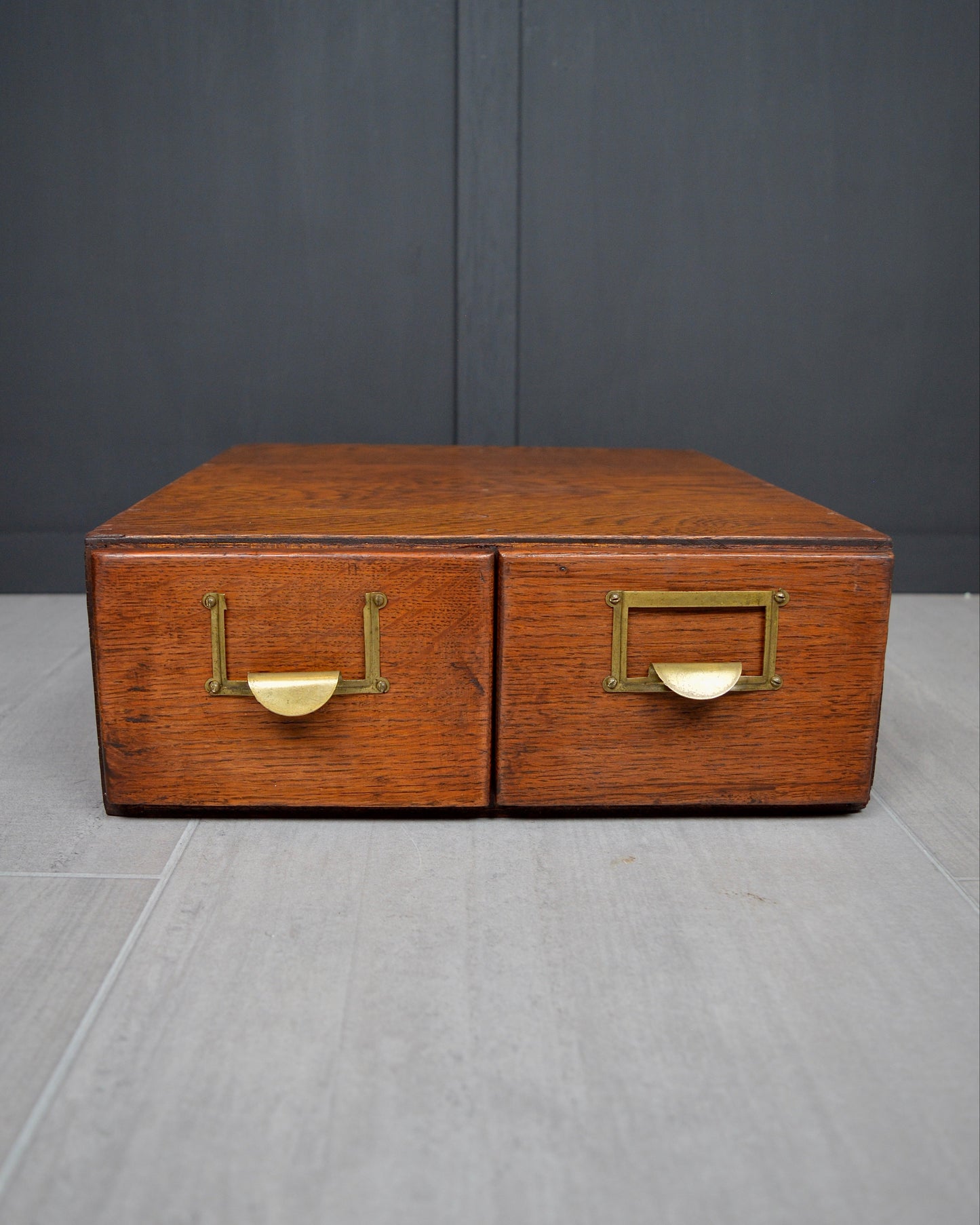 Wooden box with brass handles on a gray surface and dark background
