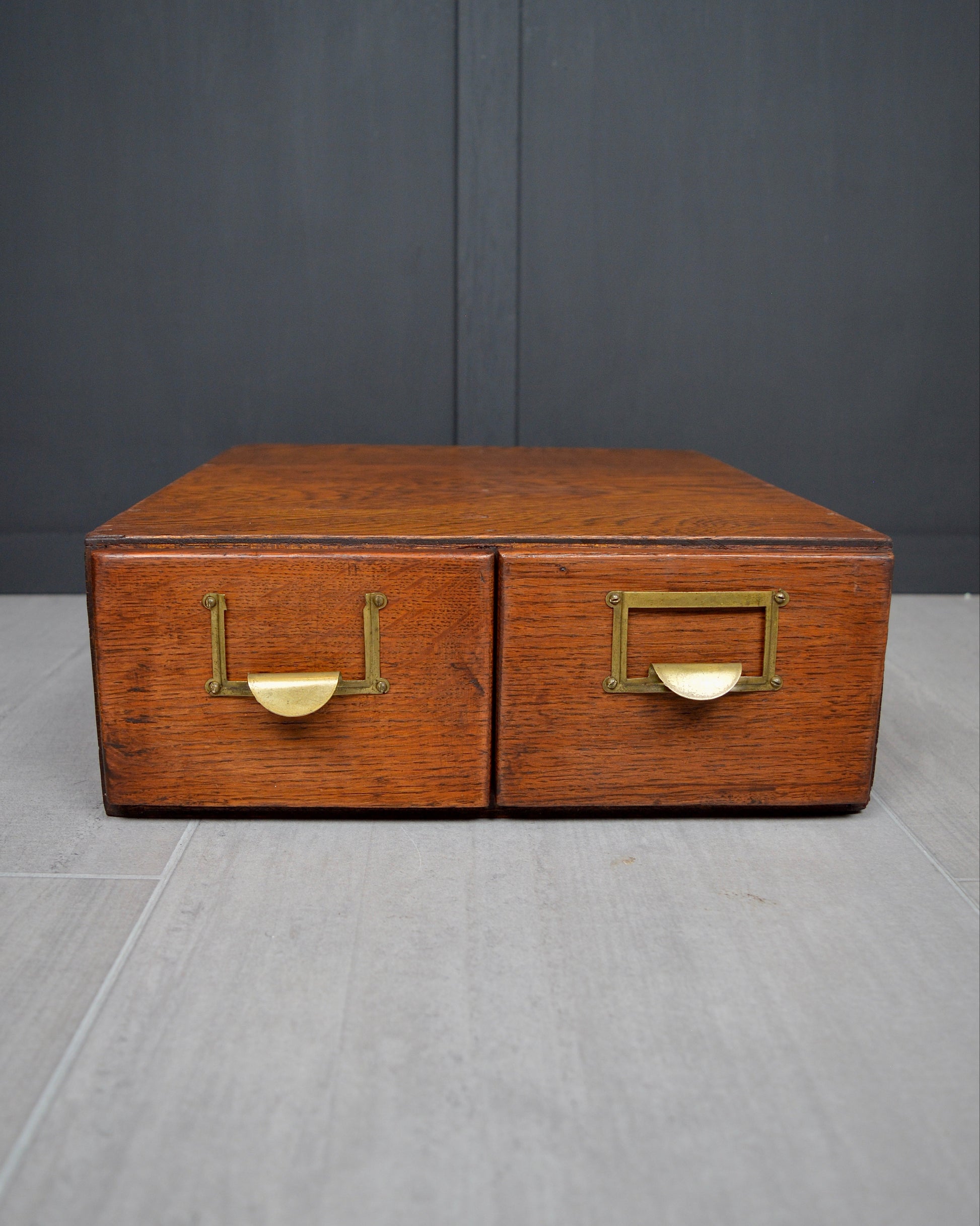 Wooden box with brass handles on a gray surface and dark background