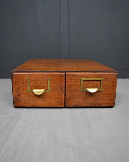 Wooden box with brass handles on a gray surface and dark background