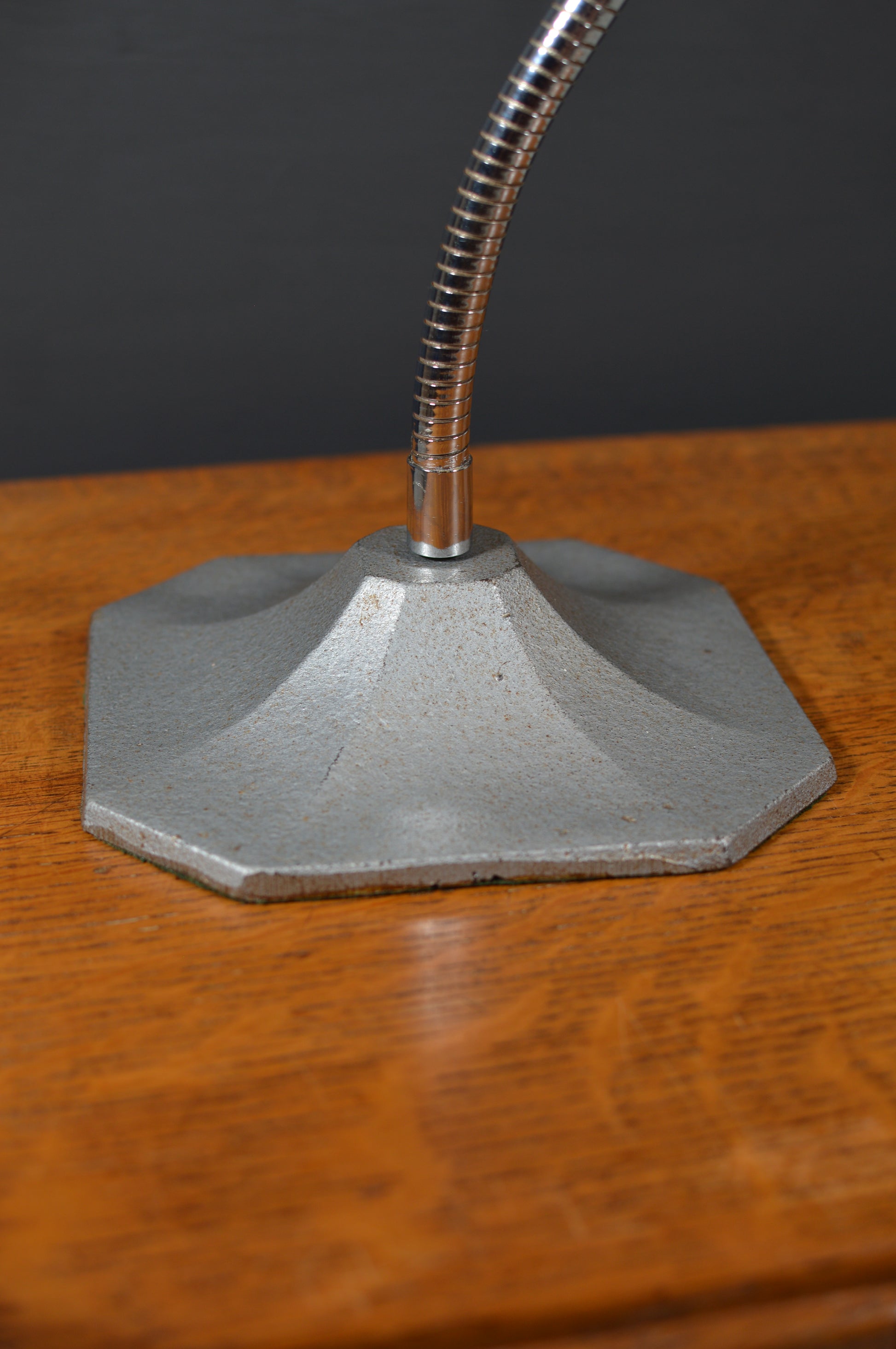 Vintage metal lamp base with flexible chrome neck on wooden surface