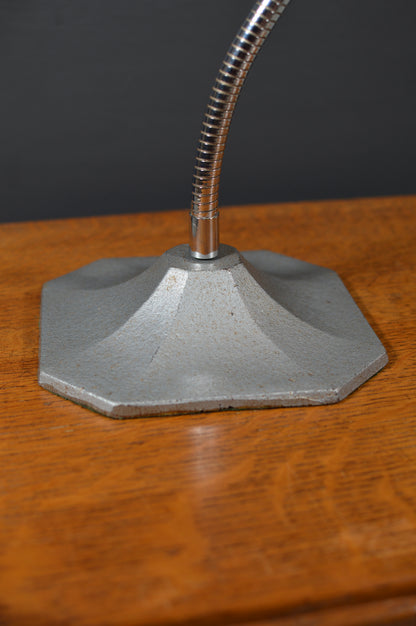 Vintage metal lamp base with flexible chrome neck on wooden surface