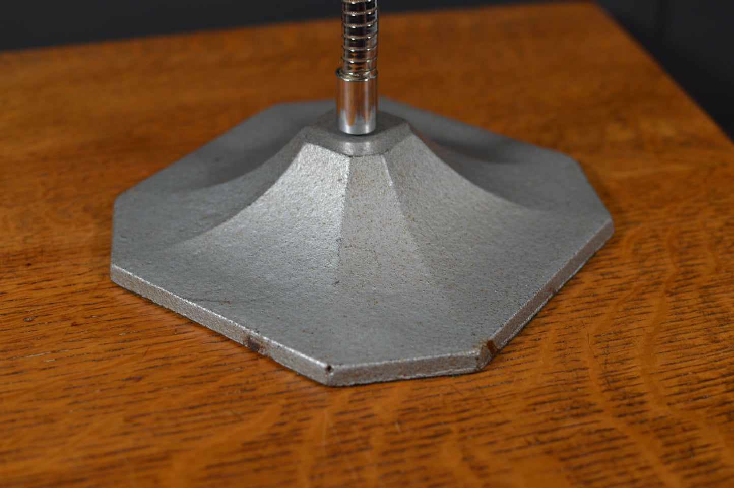 Hexagonal metal lamp base with industrial finish on wood surface